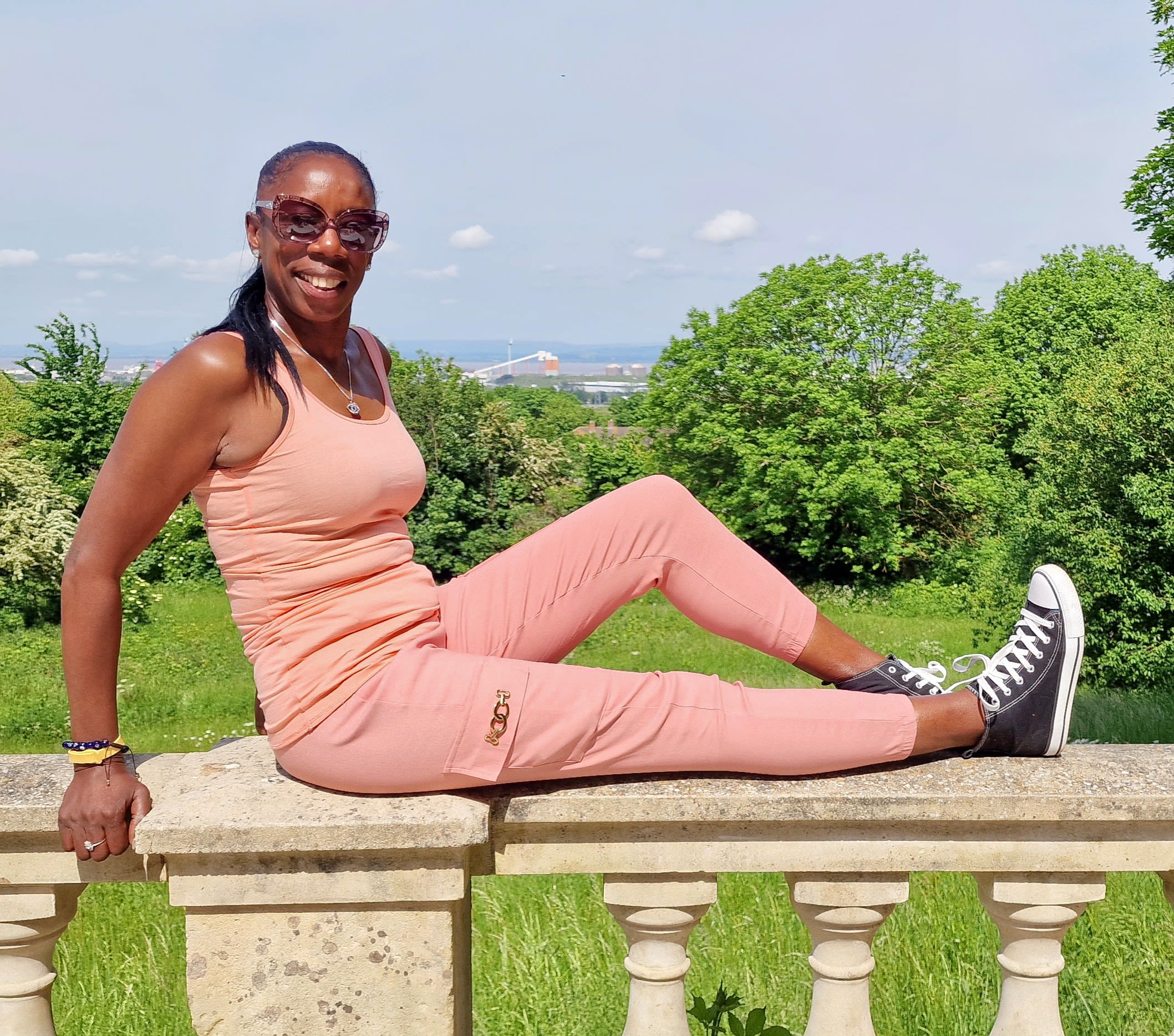 A woman in pink sportswear with trees in the background